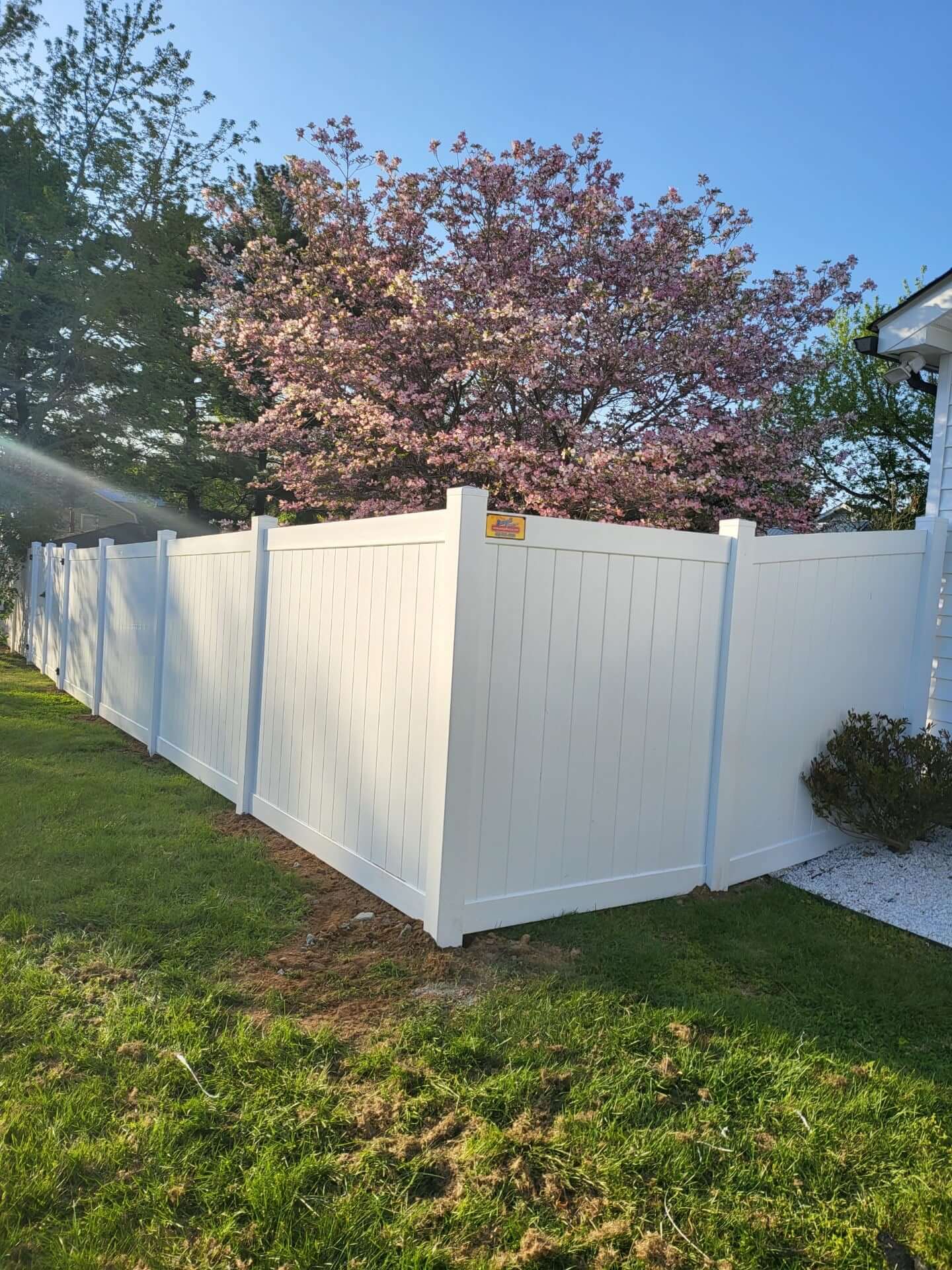 a white vinyl fence in front of a house