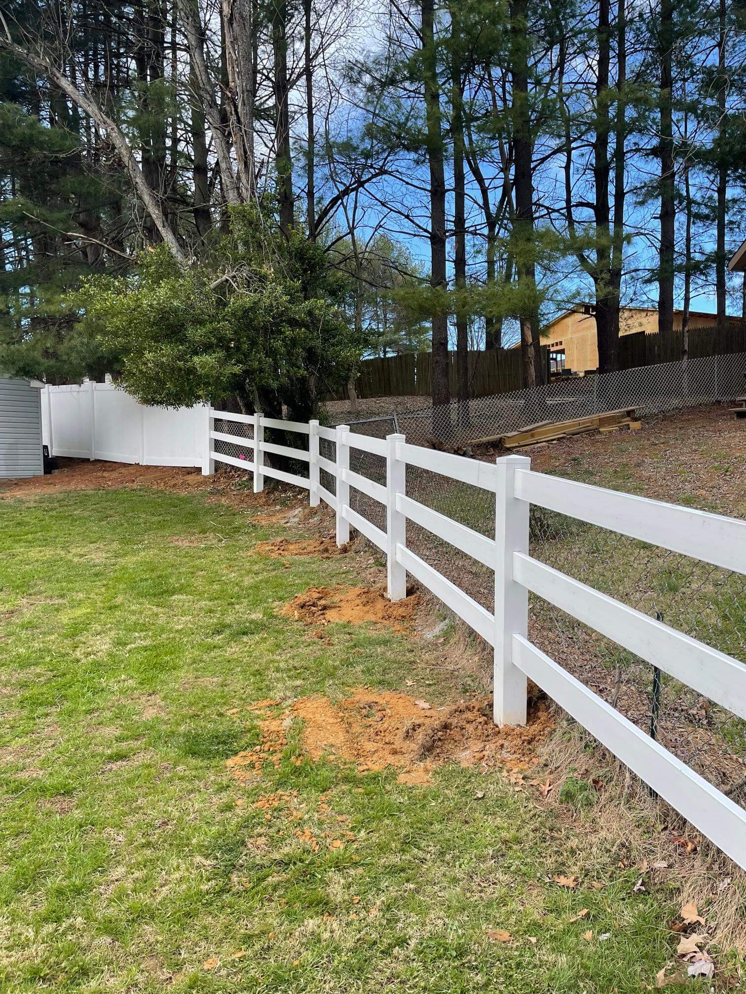 a white fence in the middle of a yard